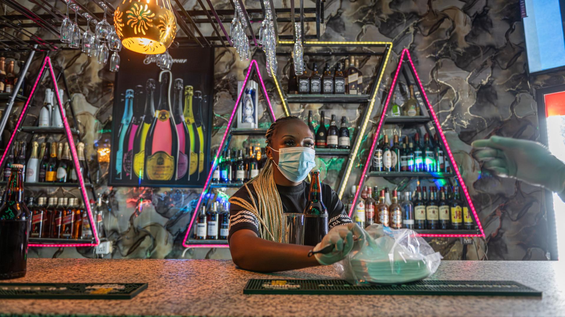 Kellnerin mit Mundschutz in einer Bar in Bunia | AP Photo/Moses Sawasawa