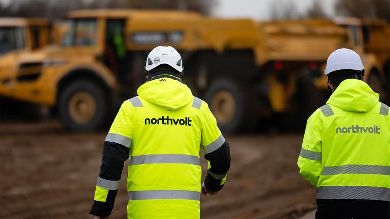 Zwei Mitarbeiter der Firma Nothvolt gehen über eine Baustelle im Kreis Dithmarschen. Hier soll die Northvolt-Batteriefabrik für Elektroautos entstehen.