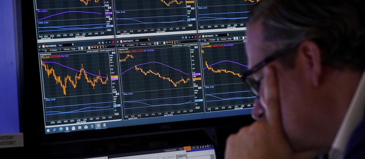 Ein Makler an der New Yorker Börse schaut auf seine Bildschirme.