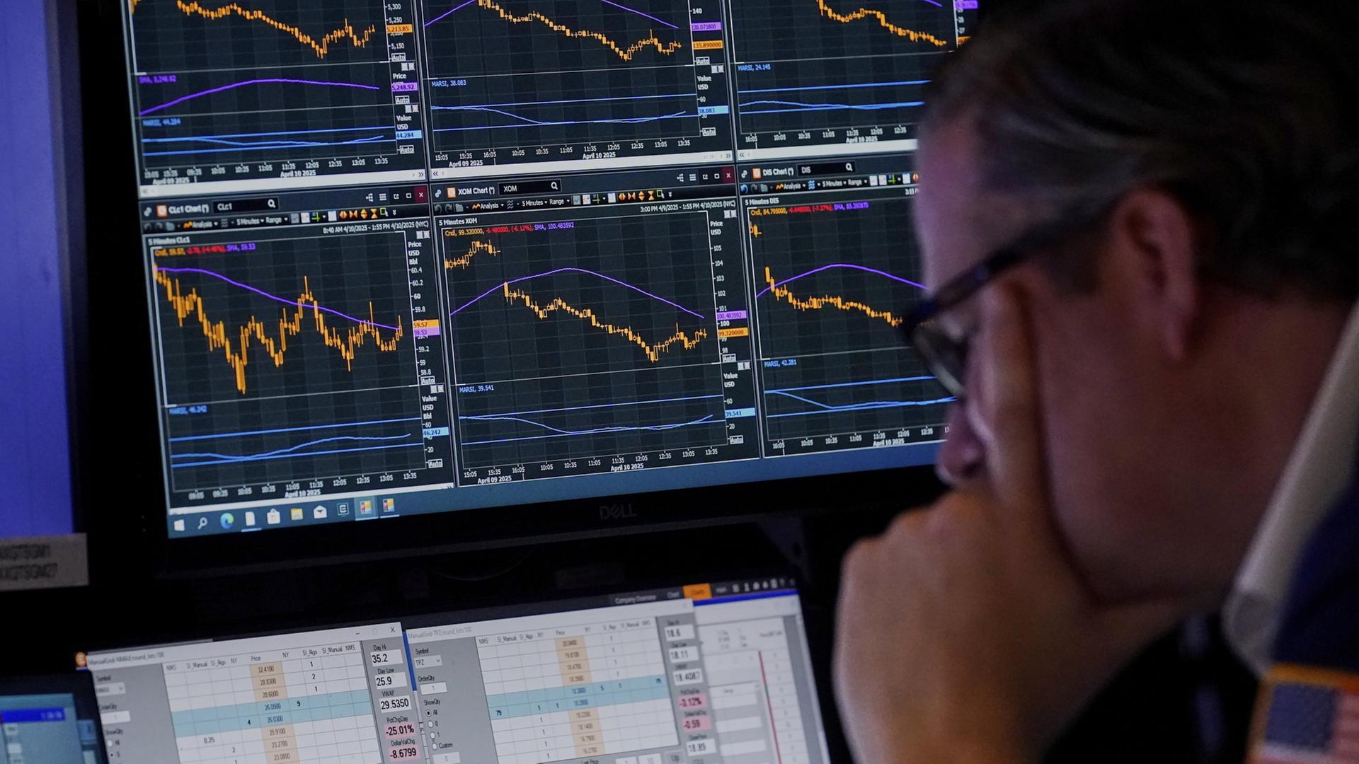 Ein Makler an der New Yorker Börse schaut auf seine Bildschirme. | AP
