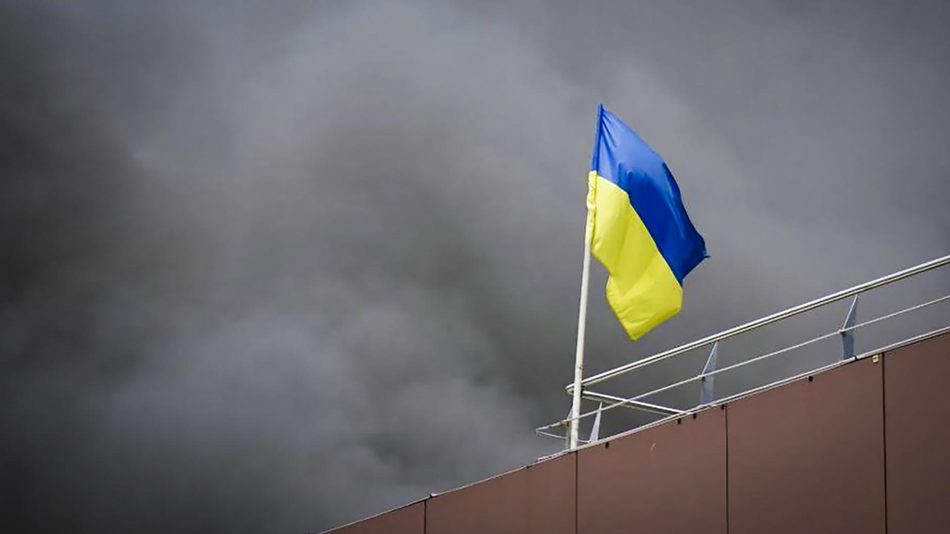 In Dnipro weht die ukrainische Flagge, während nach einem russischen Raketenangriff Rauch aufsteigt | dpa