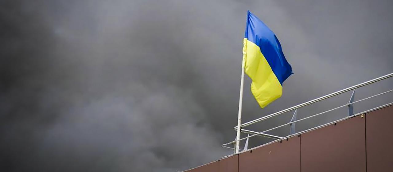 In Dnipro weht die ukrainische Flagge, während nach einem russischen Raketenangriff Rauch aufsteigt