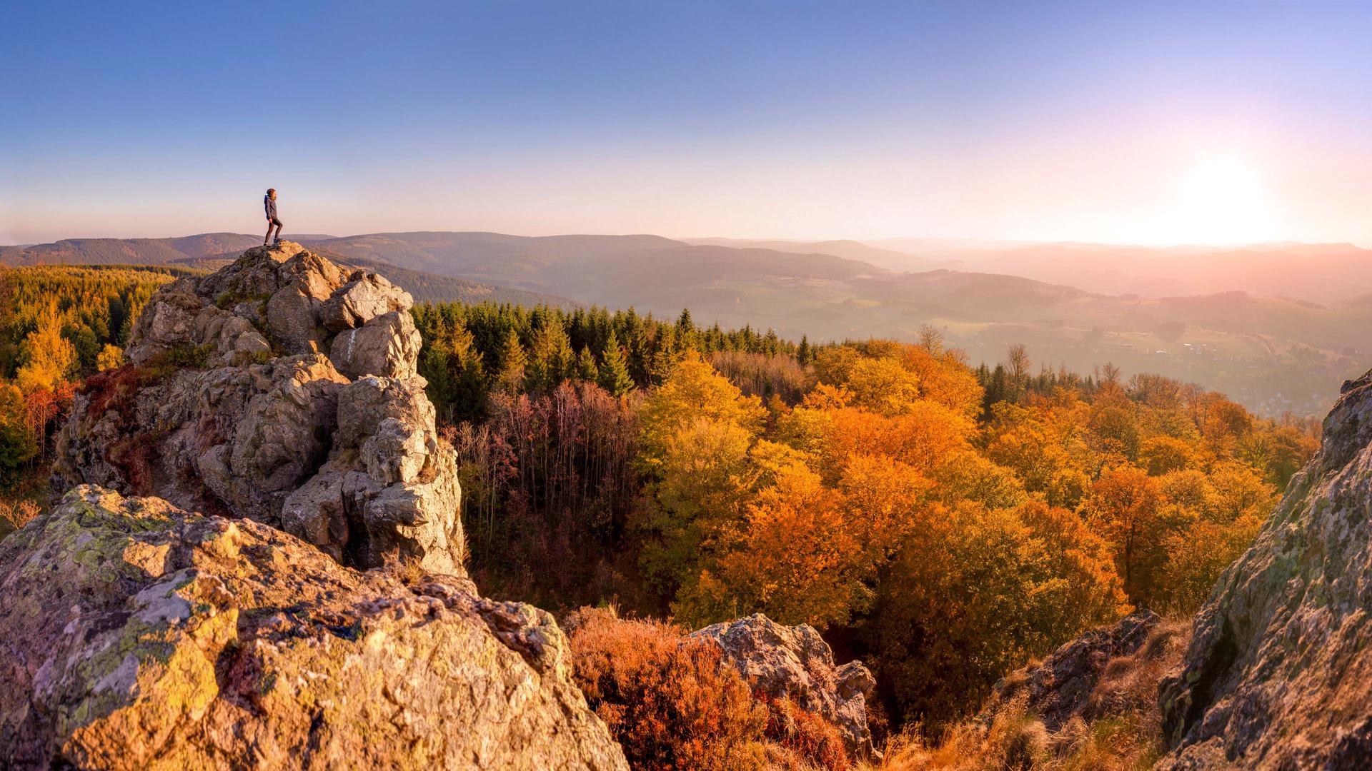 Eine junge Frau genießt die Aussicht von den Bruchhauser Steinen im Sauerland.  | WDR / mauritius images / Anne-Katrin Heine
