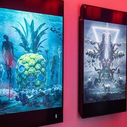 Ein Mann betrachtet die Kunstwerke des Künstlers Beeple in einer Cryptoart Ausstellung