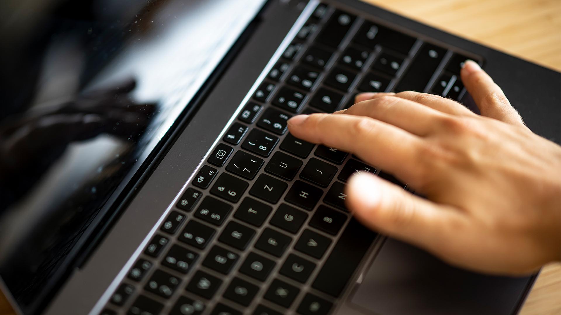 Eine Hand tippt auf der Tastatur eines Laptops. | dpa