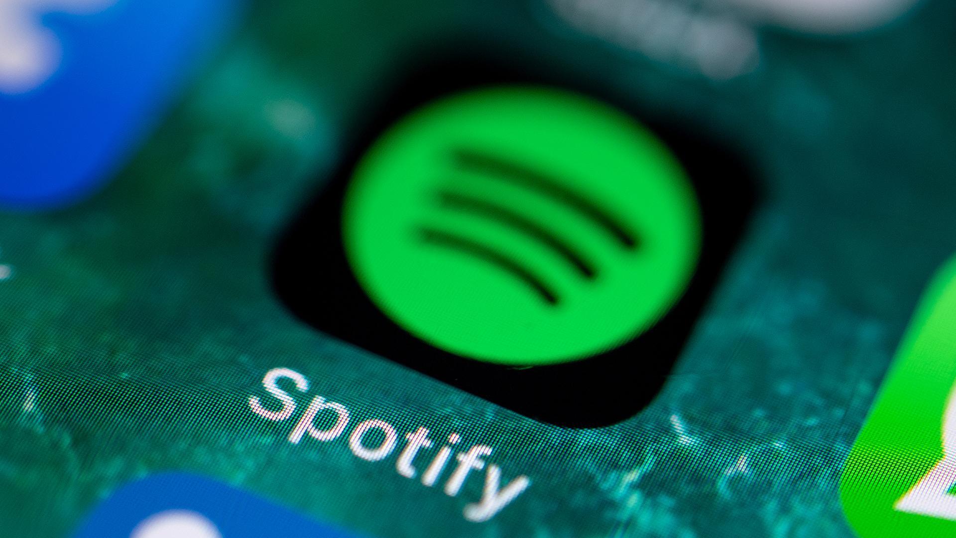 Die App des Musikdienstes Spotify wird auf dem Display eines iPhone angezeigt. | dpa