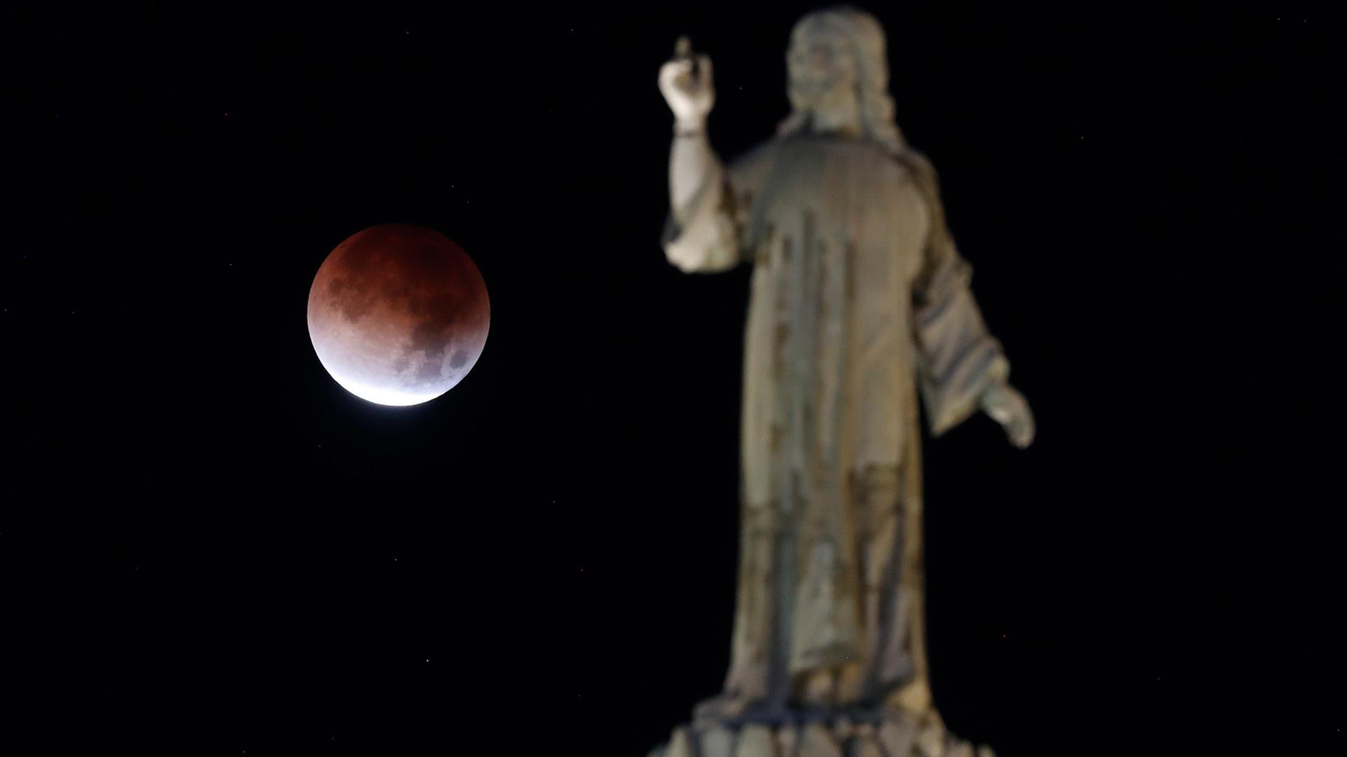 Der Mond erscheint wÃ¤hrend einer totalen Mondfinsternis hinter einer Statue in San Salvador. | EPA
