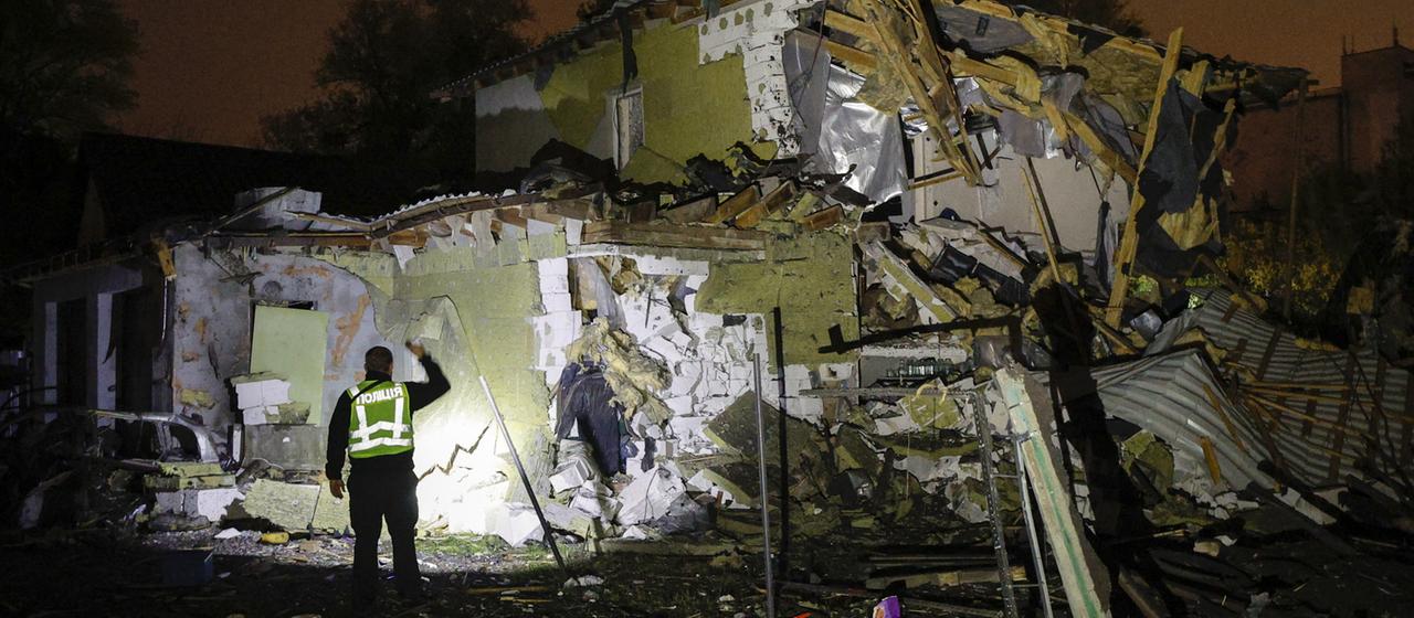 Ein ukrainischer Polizeibeamter inspiziert Schäden nach einem Raketenangriff