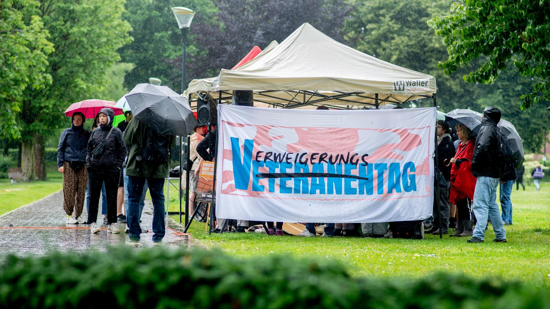 Mehrere Personen demonstrieren in der Zitadelle Vechta gegen einen Reservistenappell mit Schwurbekräftigung im Rahmen des Nationalen Veteranentags. (Archivbild vom 15.06.2025) | dpa