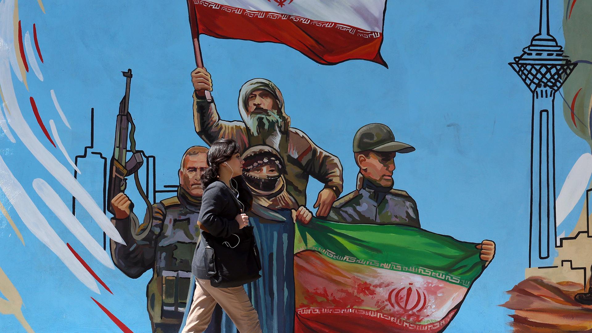 Eine Frau geht an einem politischen Wandgemälde in Teheran vorbei. | EPA