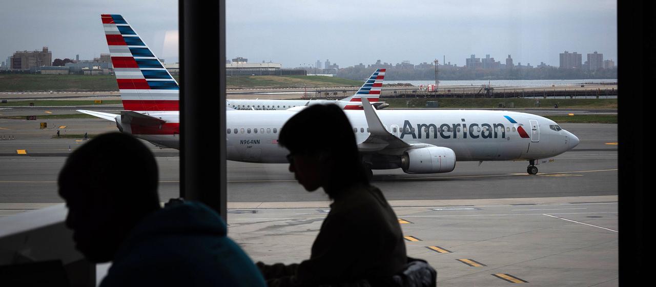 Menschen warten in einem Flughafenterminal.
