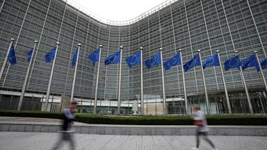 EU-Flaggen und Fußgänger vor dem EU-Hauptquartier in Brüssel