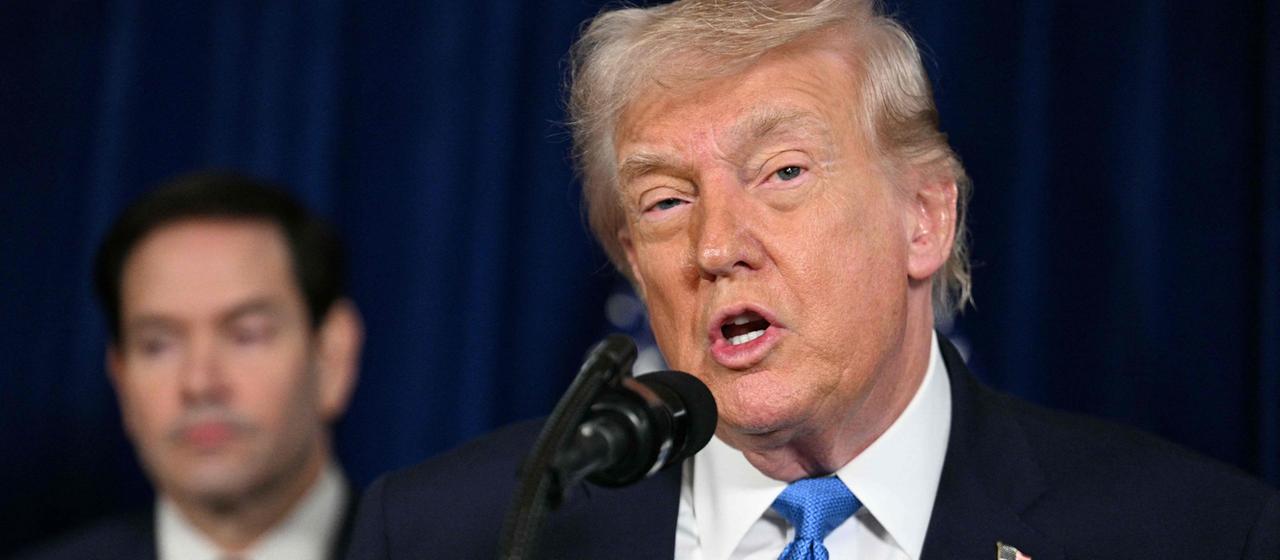 Donald Trump bei einer Pressekonferenz, dahinter Marco Rubio 