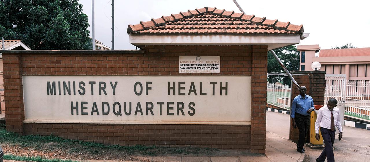 Menschen verlassen den Hauptsitz des Gesundheitsministeriums in Kampala.