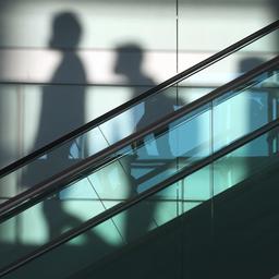 Schatten von Menschen hinter einer Rolltreppe