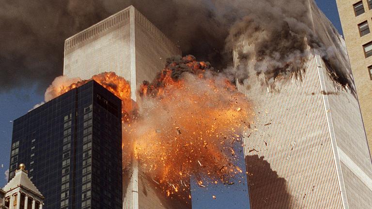 Rauch steigt aus einem der Türme des World Trade Centers auf, und aus dem zweiten Turm in New York schlagen Flammen.
