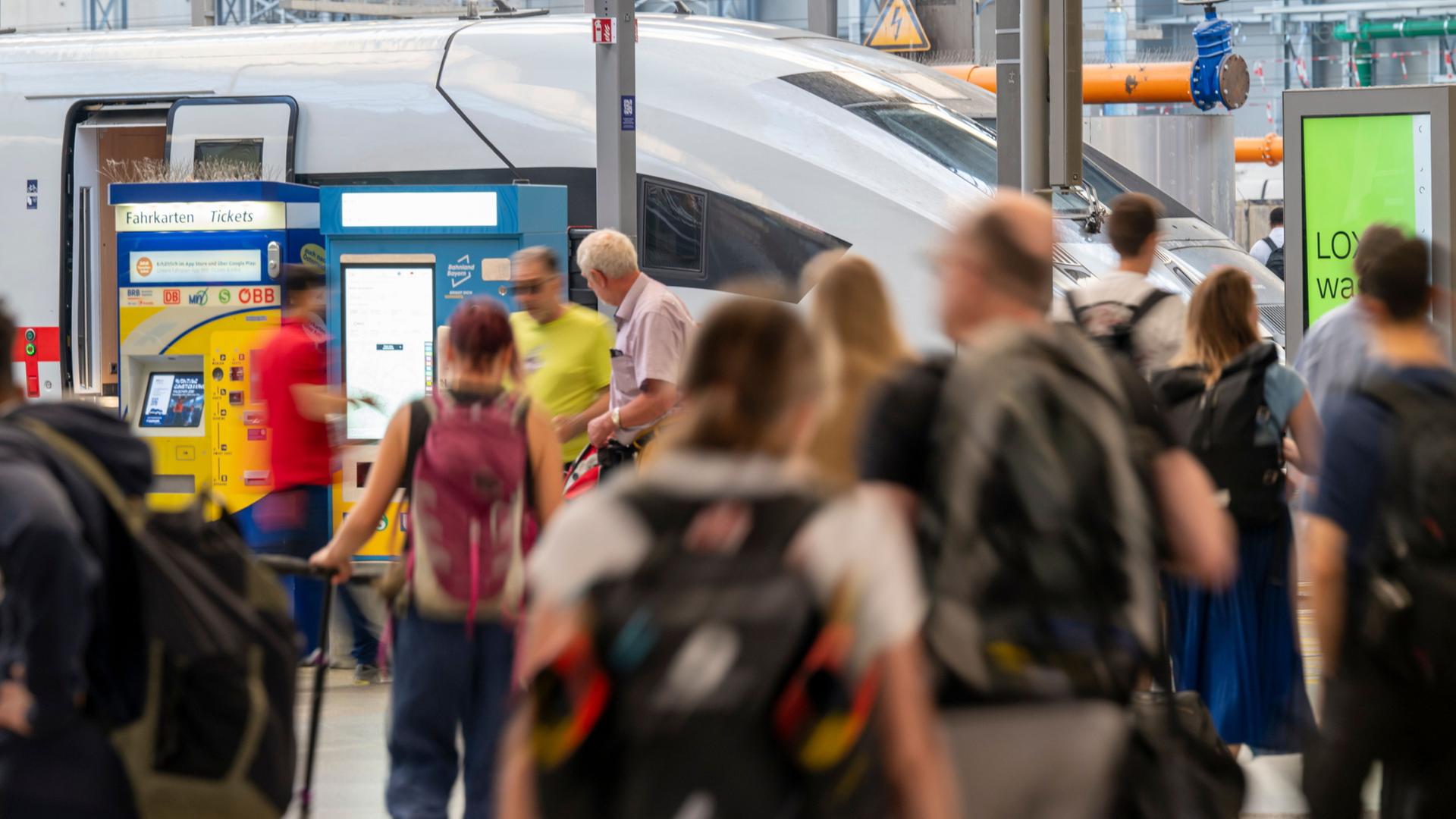Passagiere gehen über den Hauptbahnhof München zu ihren Zügen. | Peter Kneffel/dpa