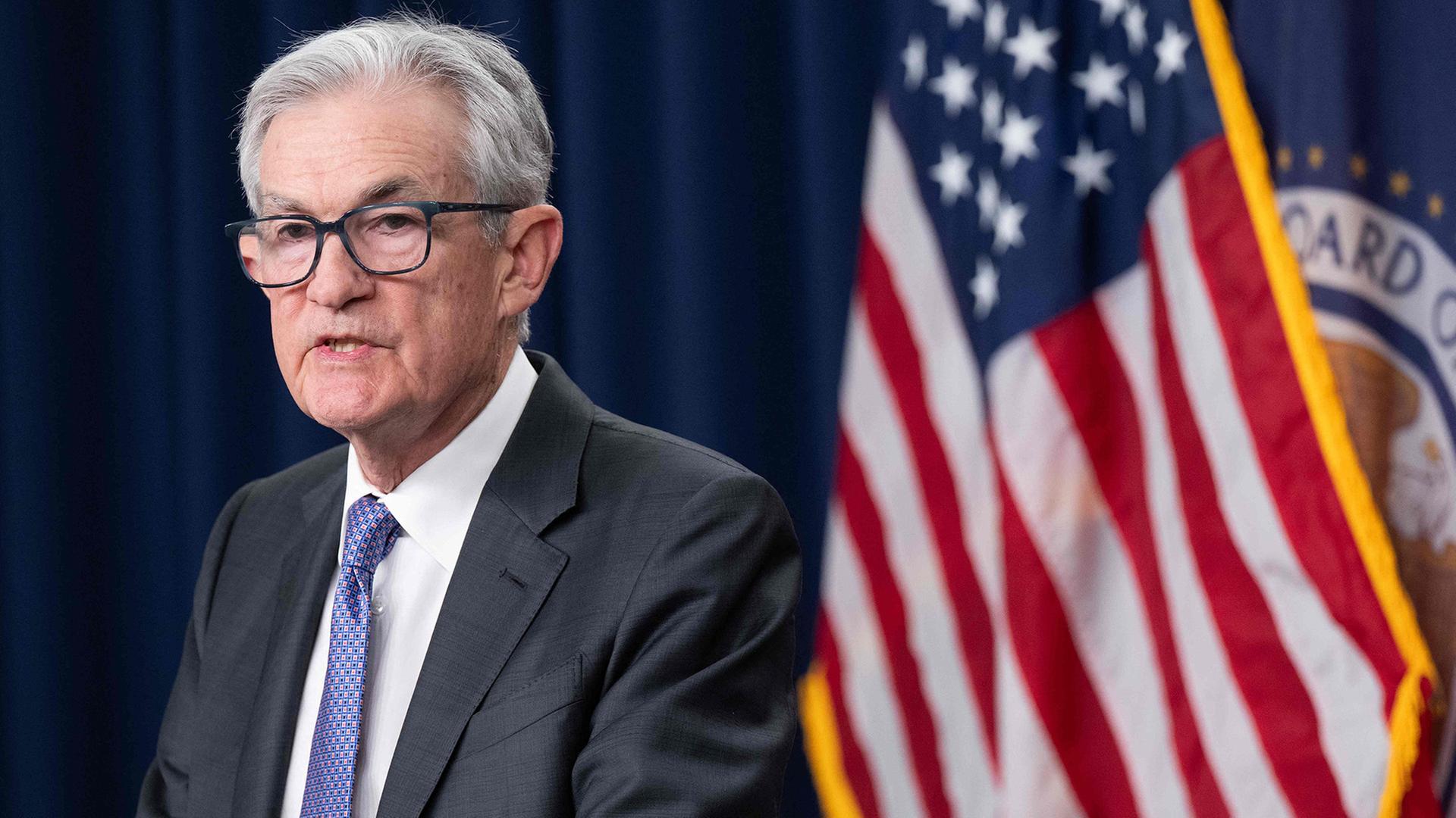 Jerome Powell steht vor einer Flagge der USA. | AFP