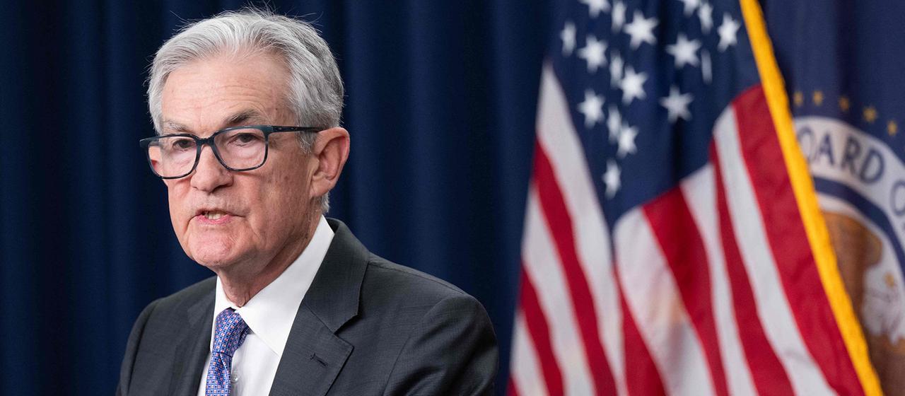 Jerome Powell steht vor einer Flagge der USA.