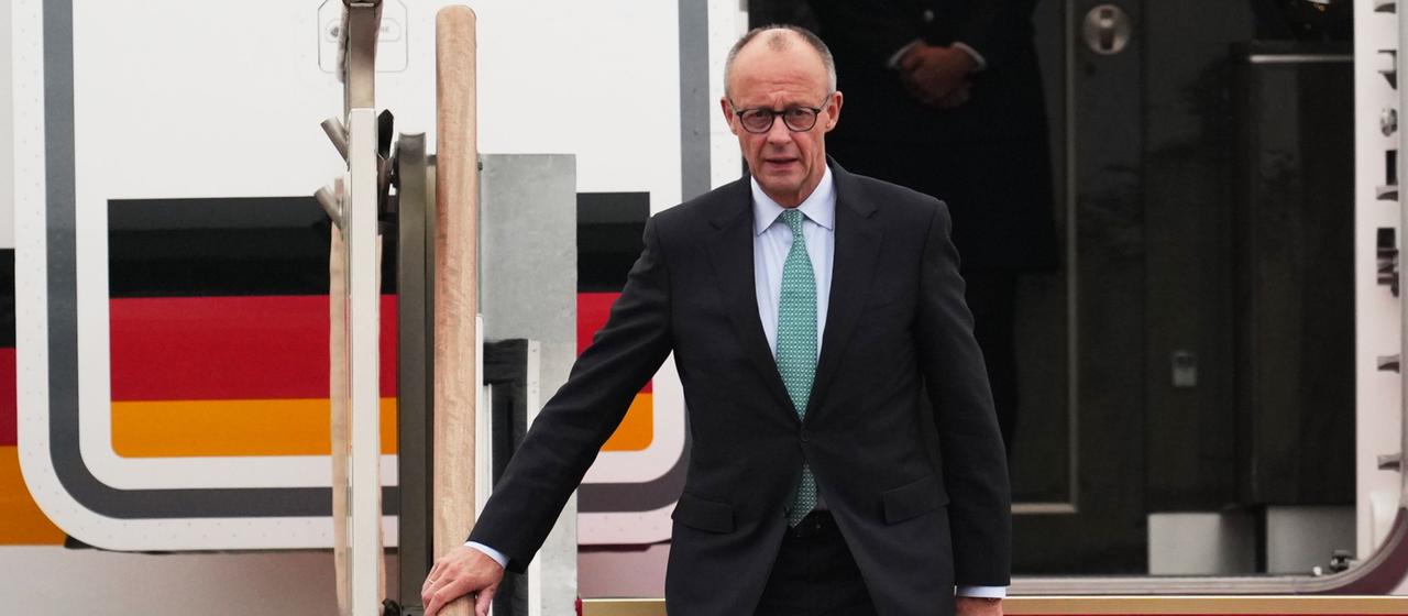 Friedrich Merz steigt aus einem Flugzeug aus.