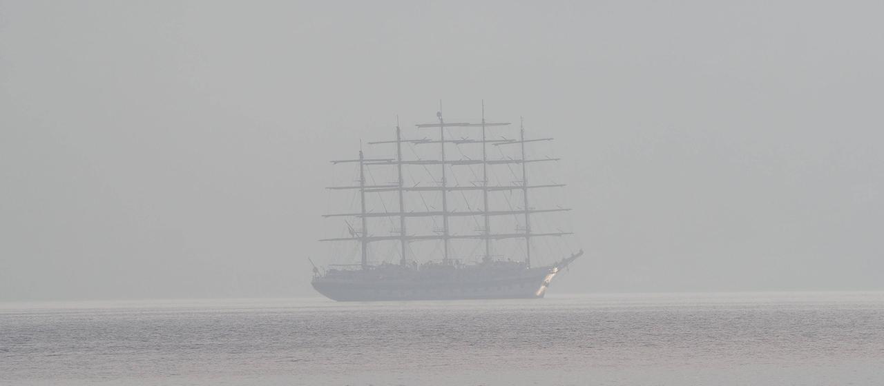 Ein Segelschiff ist in dichtem Nebel zu sehen.