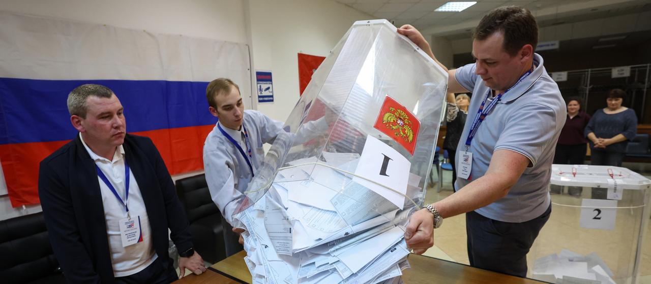 Mitglieder einer lokalen Wahlkommission leeren am Ende der Parlamentswahlen in einem Wahllokal in Podolsk in der Region Moskau eine Wahlurne.