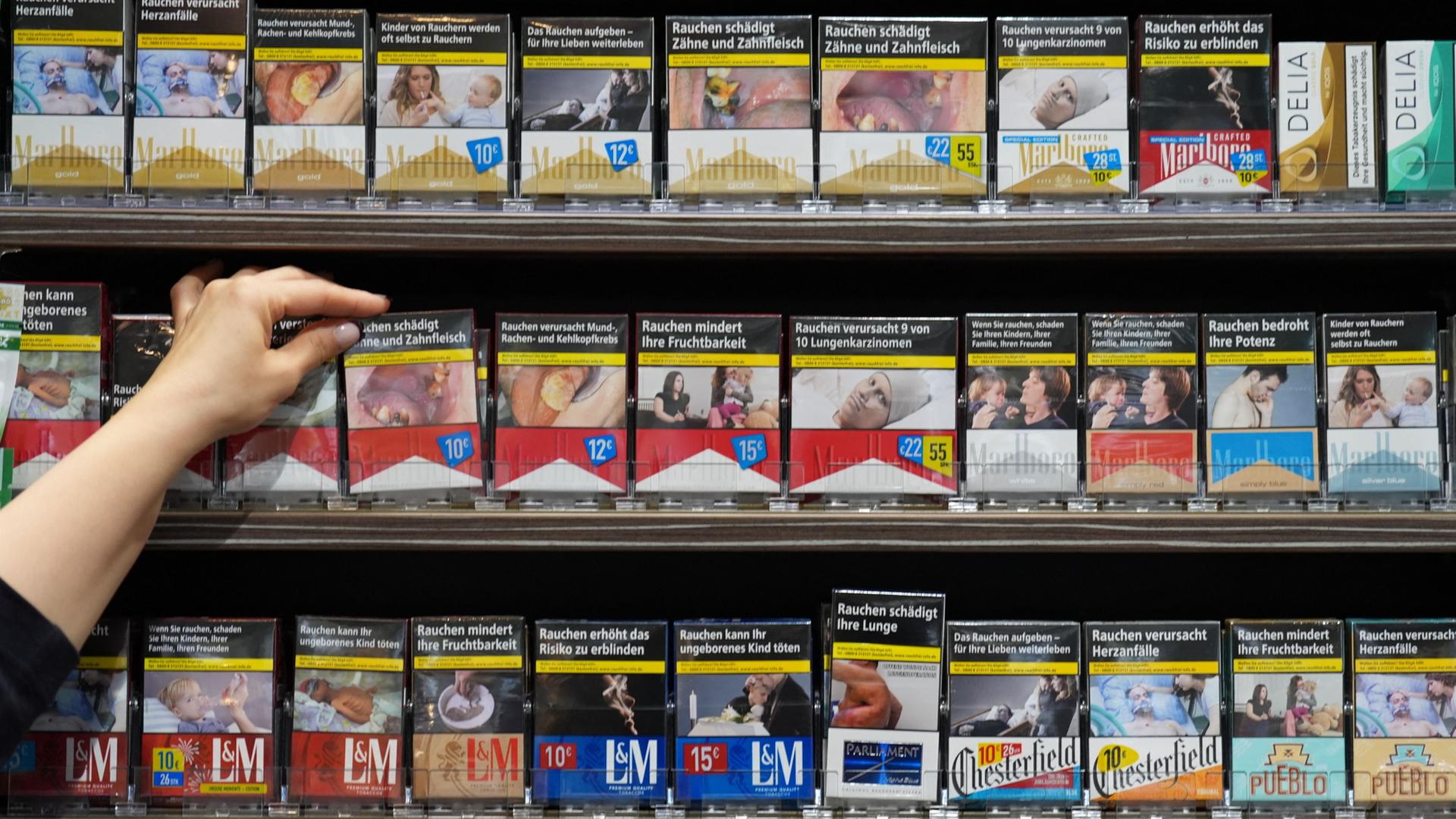Eine Mitarbeiterin greift in einem Kiosk nach einer Packung Zigaretten. | Marcus Brandt/dpa