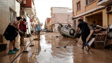 Anwohner säubern eine mit Schlamm bedeckte Straße in der vom Hochwasser betroffenen Gemeinde Paiporta in der Provinz Valencia.
