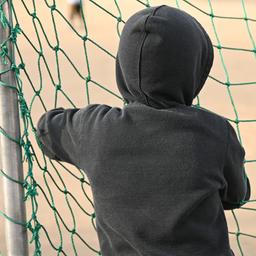 Ein Kind hält sich an einem Tornetz fest.