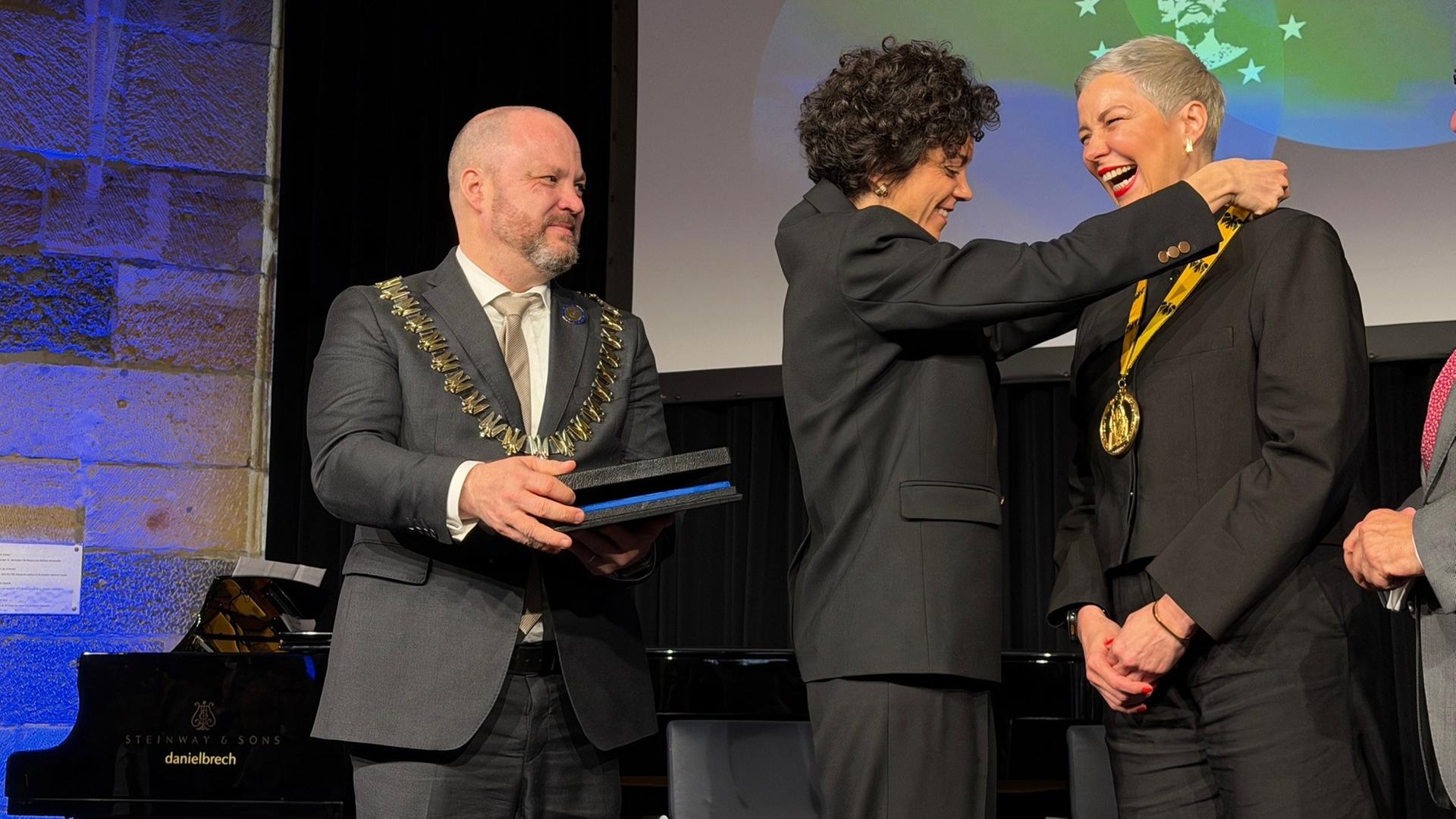 Tatsiana Khomich, die Schwester von Maria Kalesnikava, �bergibt Maria K. Den Karlspreis den sie 2022 f�r sie entgegengenommen hat | WDR/ Ingo Wagner