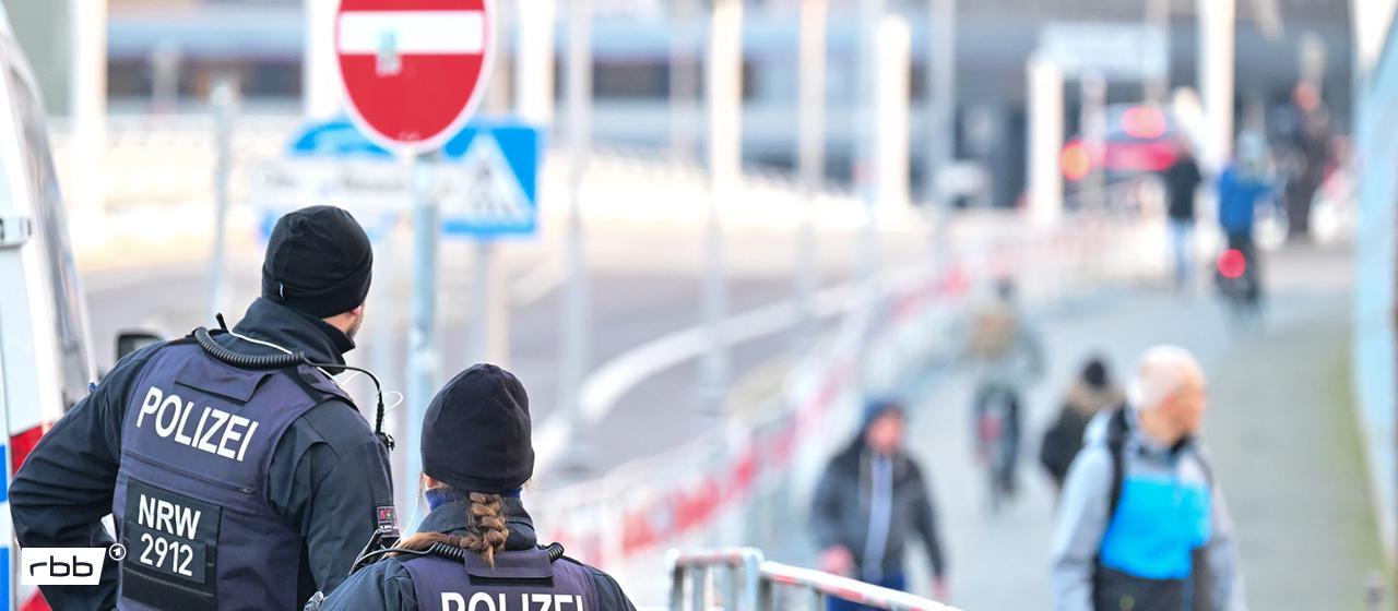 Polizeibeamte stehen am 15.12.2025 an einem Sperrgitter am Kanzleramt, an dem Passanten vorbei gehen. Heute gehen in Berlin die Beratungen über die Ukraine-Verhandlungen weiter. (Quelle: Picture Alliance/Sebastian Gollnow)