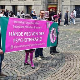 Auf einem Banner steht: "Hände weg von der Psychotherapie!"