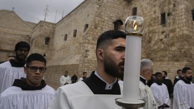 Katholische Geistliche gehen am Heiligabend in der Stadt Bethlehem im Westjordanland in einer Prozession neben der Geburtskirche.