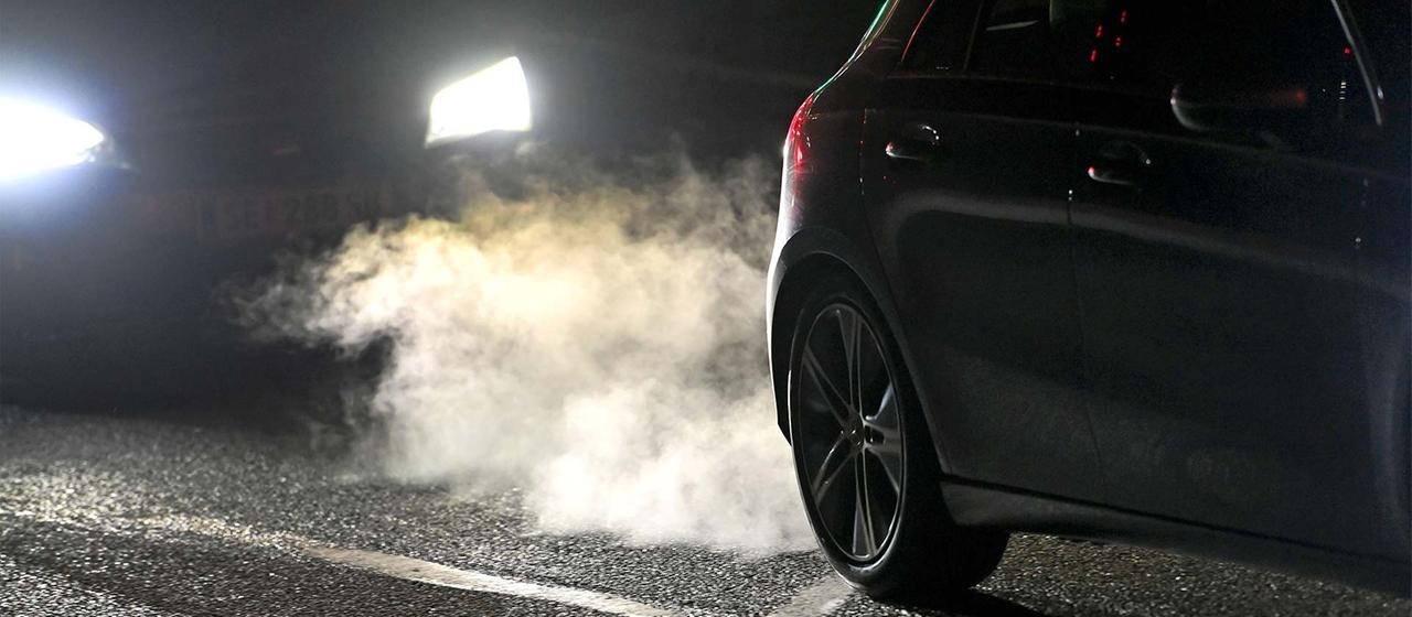 Abgase kommen aus dem Auspuff eines Autos.