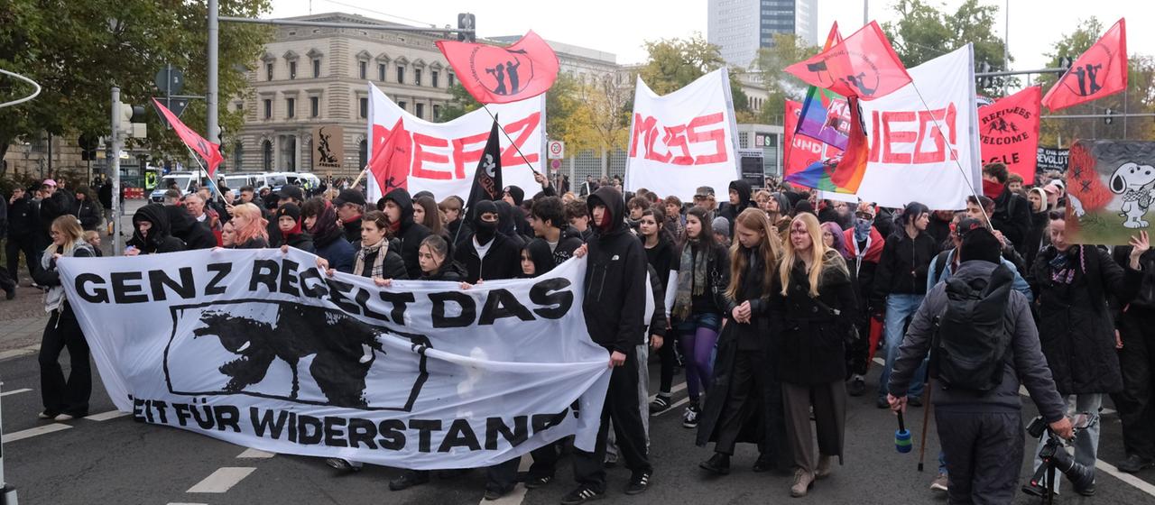 Teilnehmer einer Demonstration laufen auf der Straße.