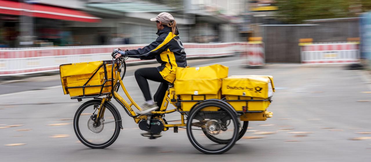 Postbotin der Deutschen Post auf einem E-Bike