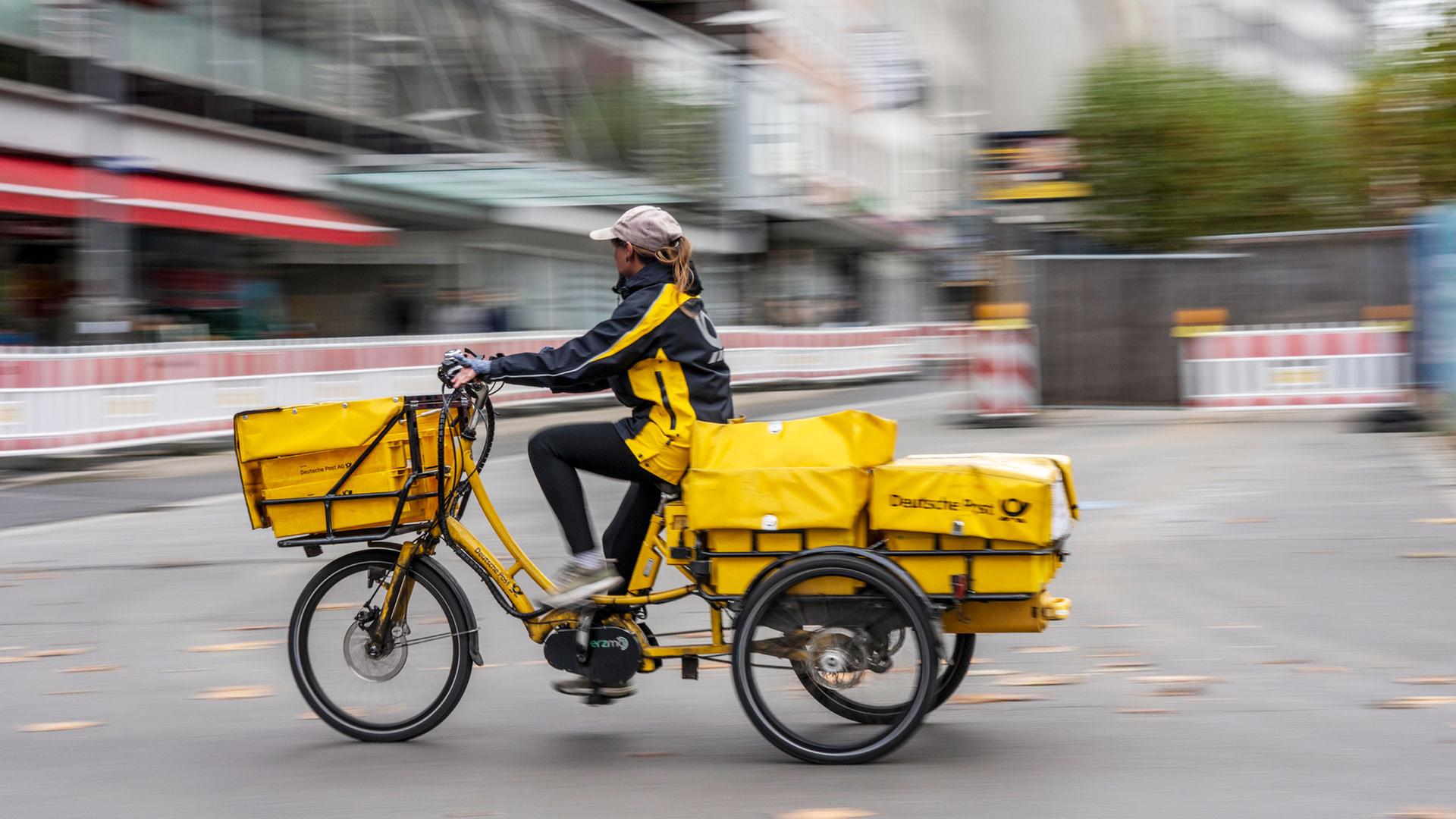 Postbotin der Deutschen Post auf einem E-Bike | 