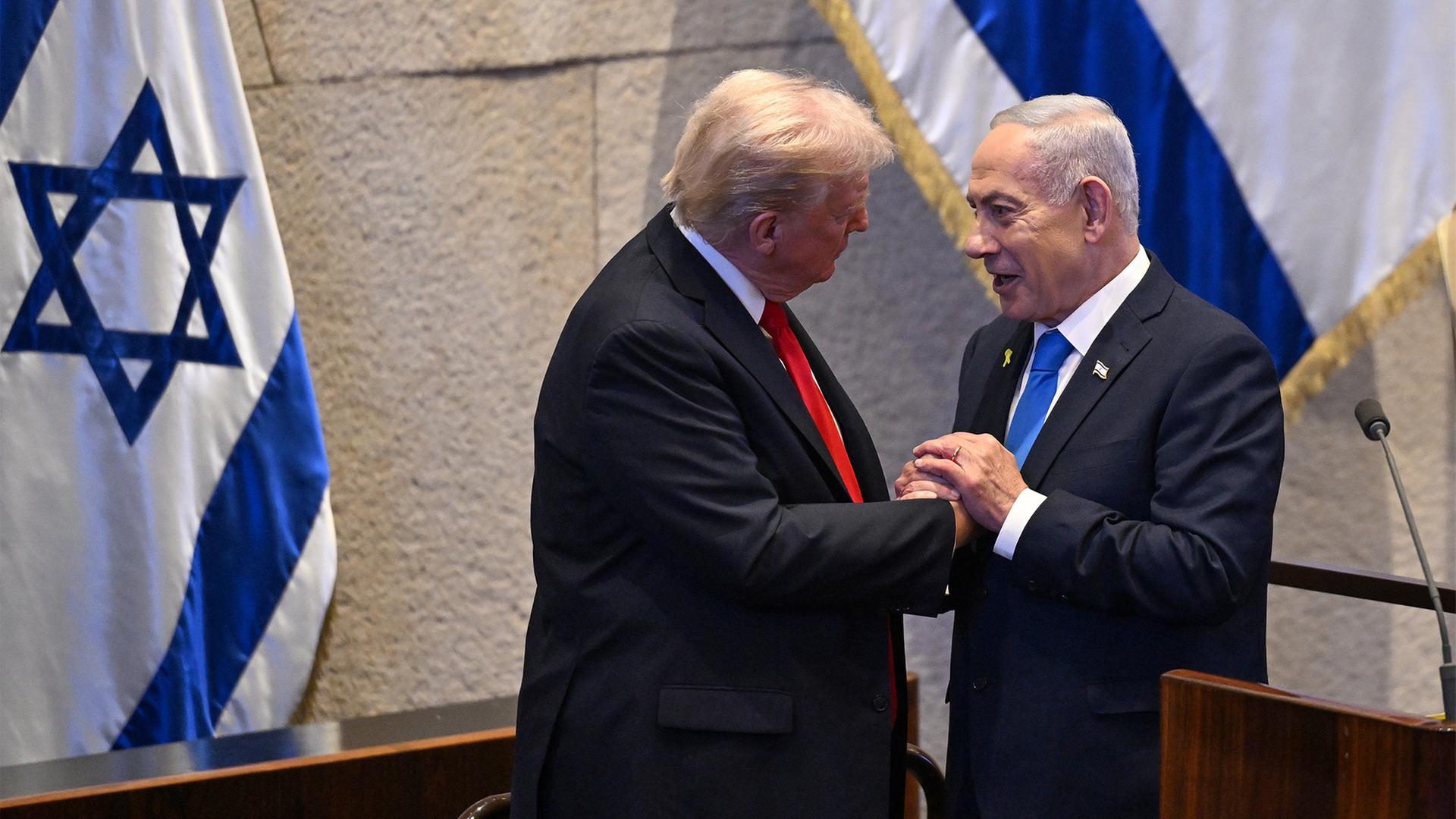 Donald Trump reicht Benjamin Netanjahu in der Knesset die Hand. | dpa