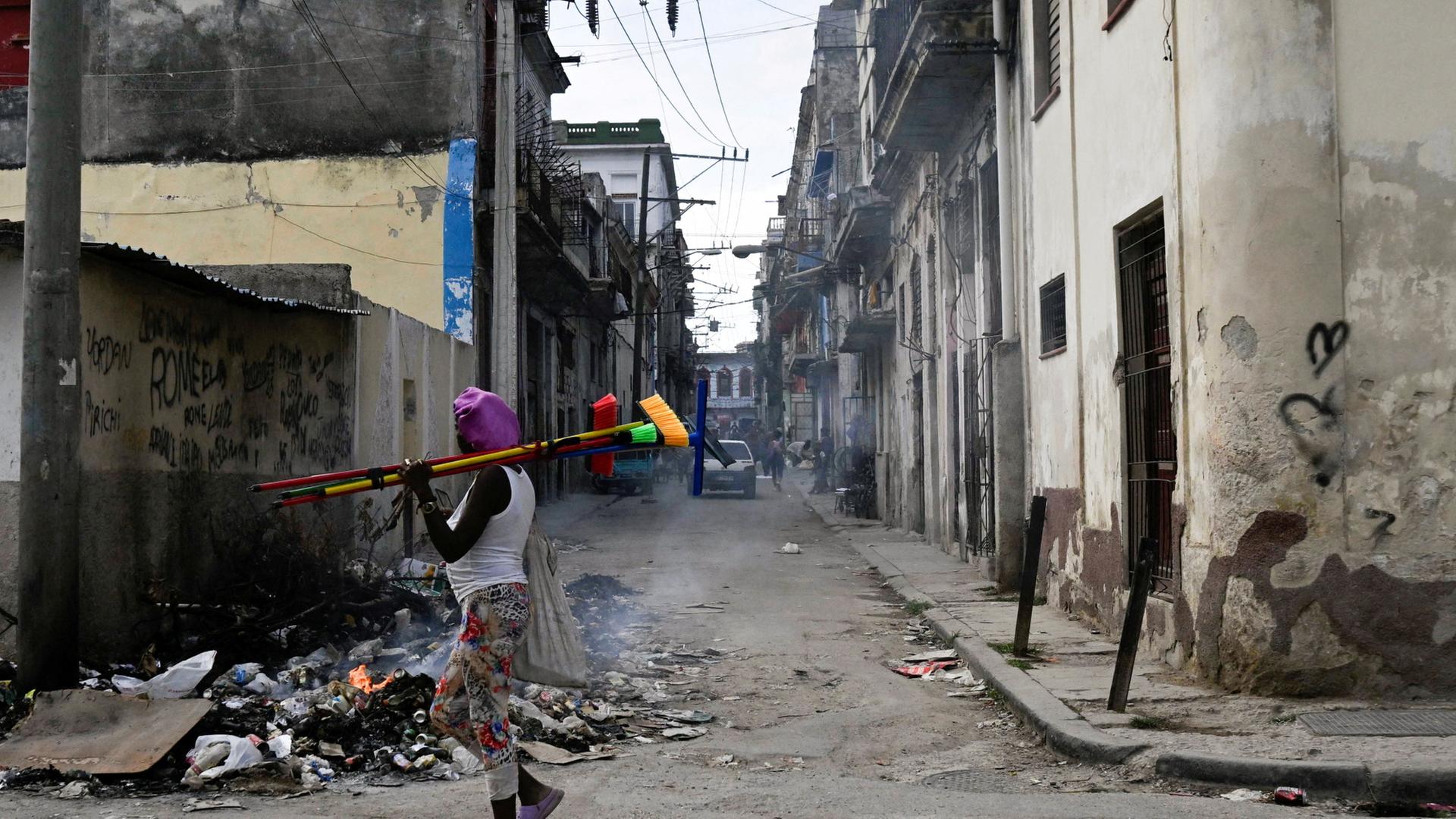 Ein Straßenverkäufer geht an einem brennenden Müllhaufen in Havanna vorbei. | REUTERS