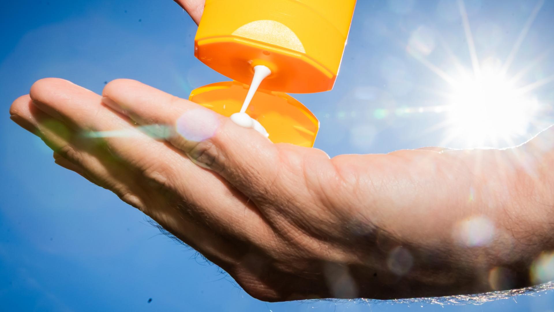 Sonnencreme fließt in eine Hand