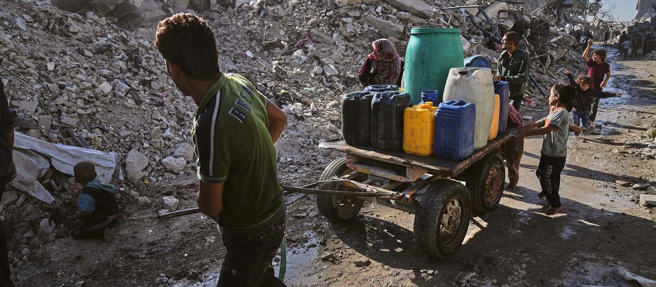 Palästinenser transportieren Wasser auf einem Karren inmitten der Ruinen von Gaza-Stadt. | AP Palästinenser transportieren Wasser auf einem Karren inmitten der Ruinen von Gaza-Stadt.