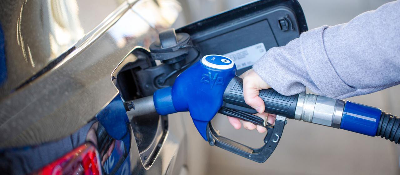 Eie Kundin betankt ein Auto an einer Tankstelle.