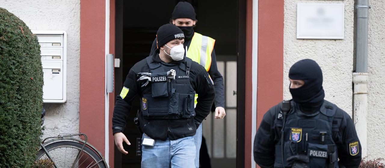 Bei einer Razzia gegen sogenannte Reichsbürger stehen Polizisten an einem durchsuchten Objekt in Frankfurt.