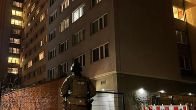 Ein Polizist steht in der Nacht vor einem Hochhaus in Berlin-Friedrichshain.