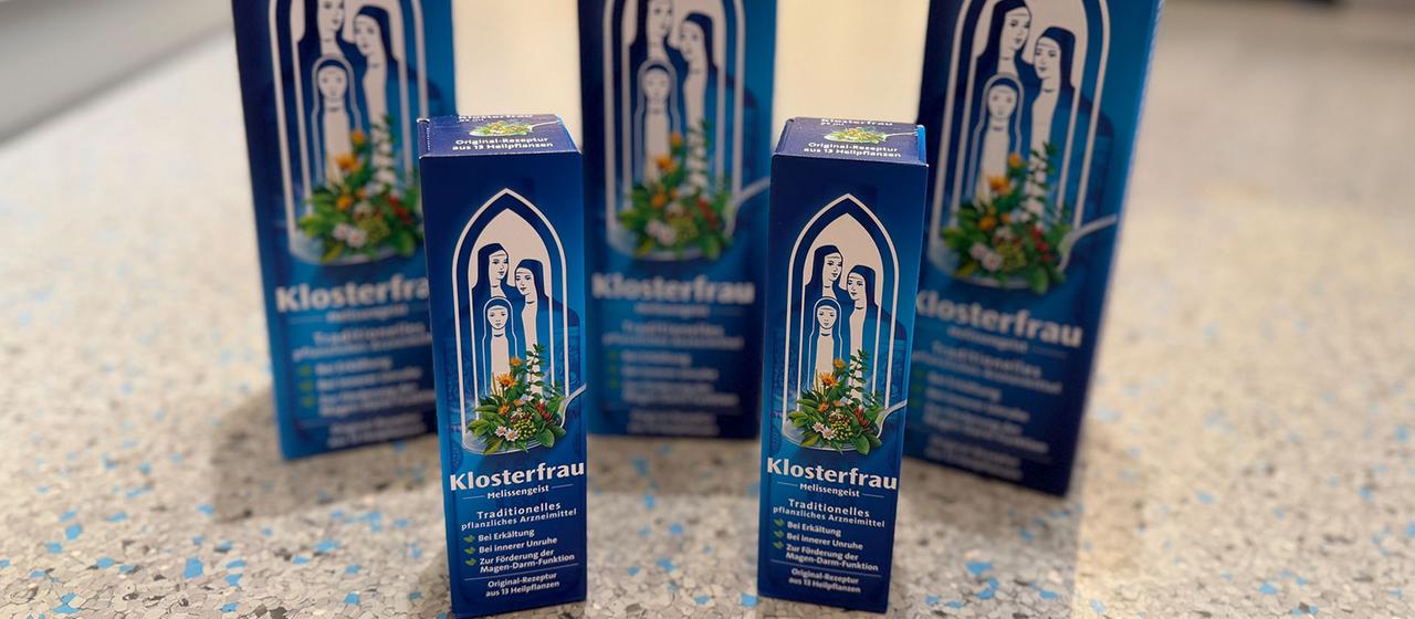 Verpackungen von Klosterfrau Melissengeist stehen auf einem Tisch.