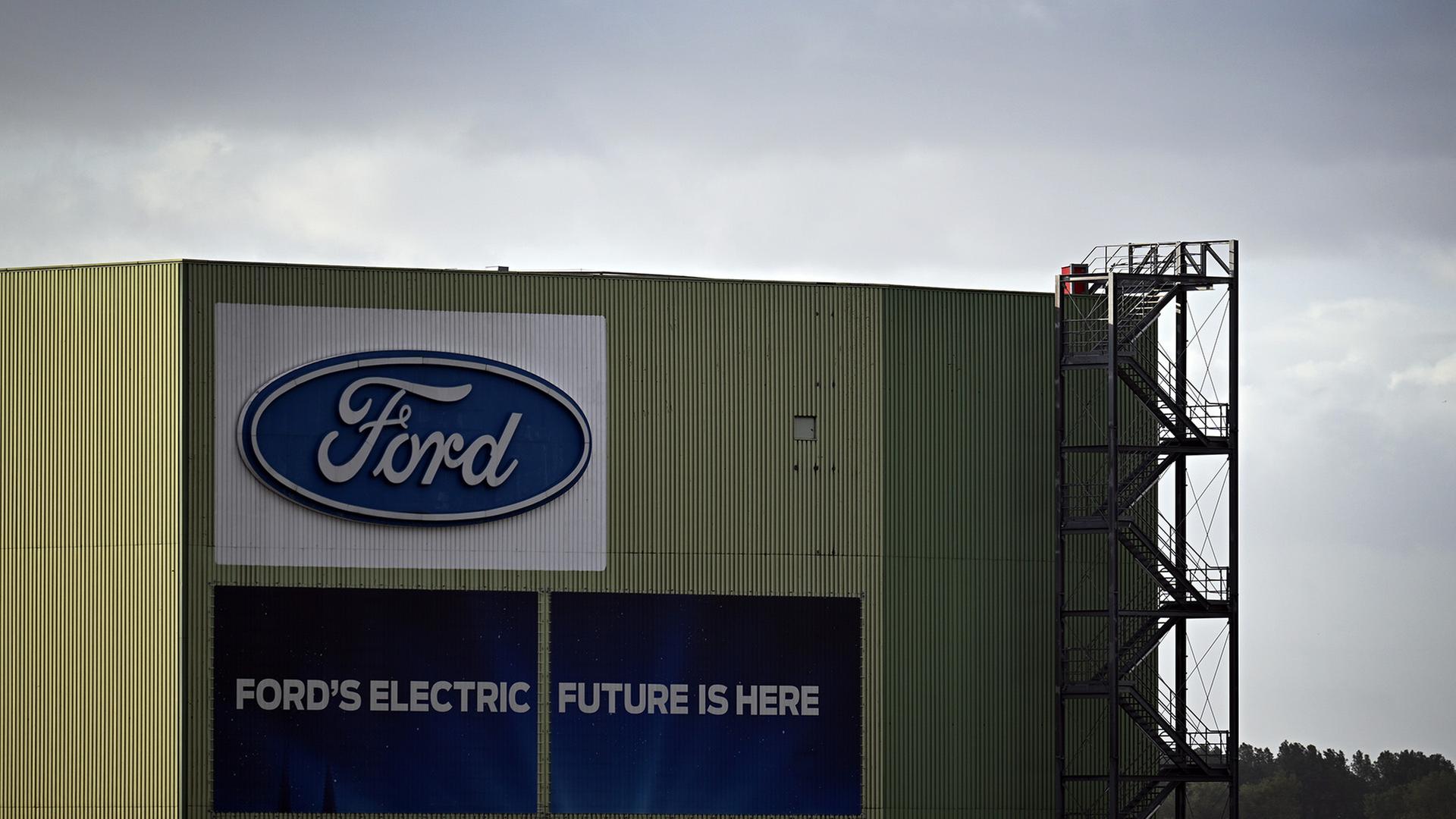  Wolken ziehen über ein Gebäude mit dem Ford-Logo auf dem Gelände der Ford-Werke. | dpa