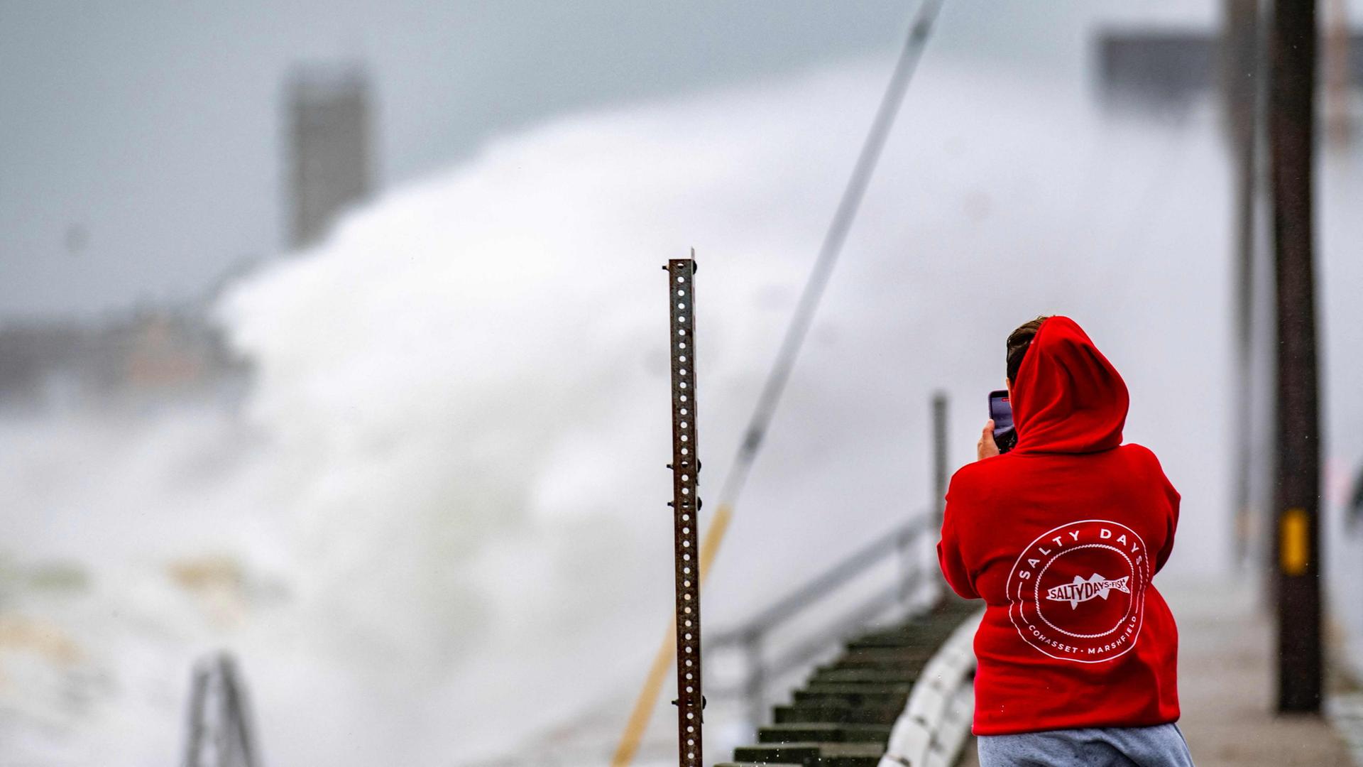 Ein Mensch fotografiert in Scituate, Massachusetts, meterhohe Wellen während eines Unwetters. | AFP