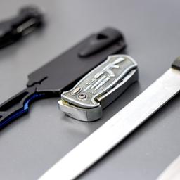 Mehrere sichergestellte Stichwaffen liegen auf einem Tisch.