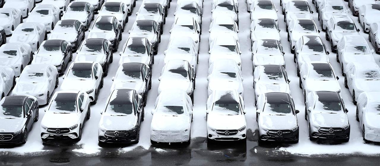 Zahlreiche mit Schnee bedeckte Autos auf Parkflächen, Auto Terminal Bremerhaven