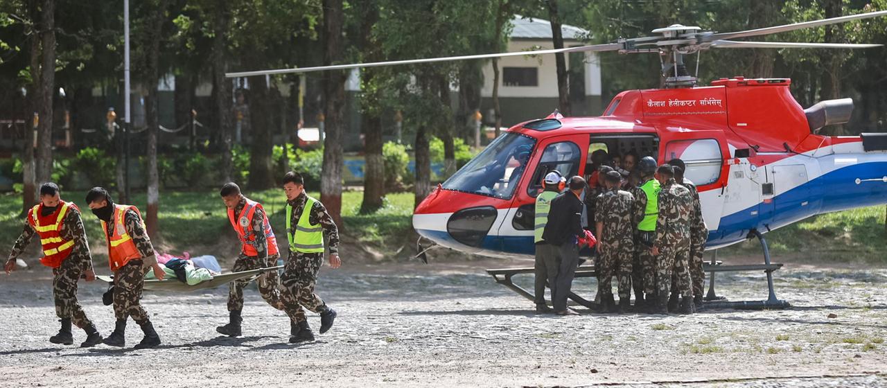Soldaten tragen in der Stadt Battar Bazar im nepalesischen Distrikt Nuwakot einen geretteten Einwohner in ein Militärlager.